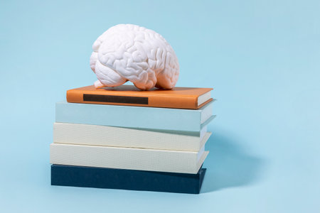 brain health and dementia series, stacked books and brain miniatureの写真素材