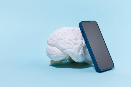 brain health and dementia series, a brain miniature and cell phoneの写真素材