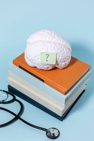 brain health and dementia series, stacked books and brain miniature, stethoscope