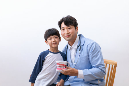 Asian Korean doctors and children holding miniatures of teethの写真素材