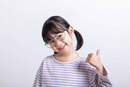 Asian Korean child with thumbs up hand motion