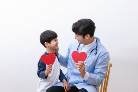 Asian Korean child and doctor holding a heart shape panelの写真素材