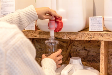 eco friendly habits hand gesture_refilling detergent at zero waste shop