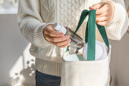 eco friendly habits hand gesture_empty bottle in the eco bag