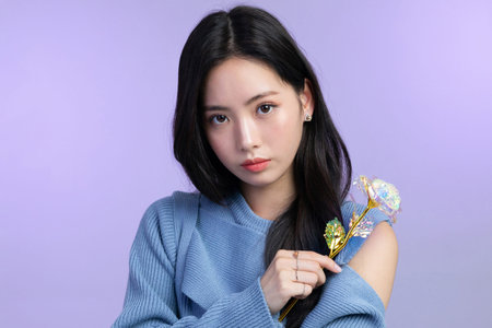 beautiful young Korean Asian woman portrait studio photo in winter skin beauty and cosmetics concept__holding a flowerの写真素材