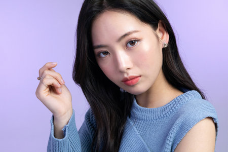 beautiful young Korean Asian woman portrait studio photo in winter skin beauty and cosmetics concept__touching lipsの写真素材