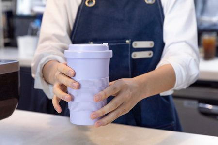 barista handing tumblers in cafe