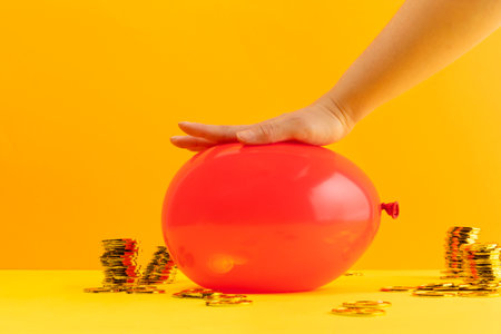 conceptual creative photo of monetary inflation, economic recession, crisis_pressing hands and coinsの写真素材