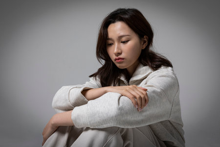 stressed, depressed Korean business woman in pink suit, worryingの写真素材