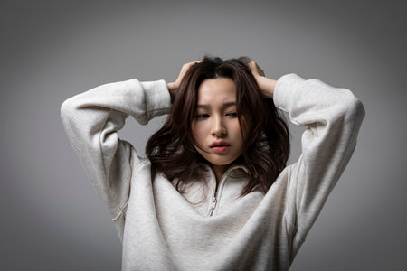 stressed, depressed Korean business woman in pink suit, worryingの写真素材