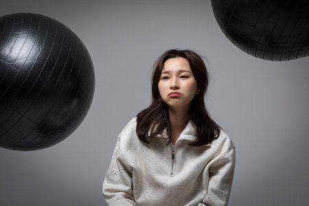 stressed, depressed Korean business woman in pink suit, worryingの写真素材