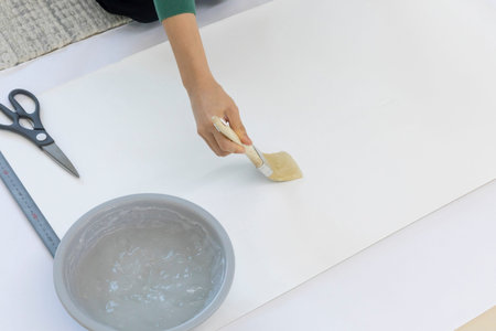 DIY interior hand motion, closeup_apply paste to wallpaper