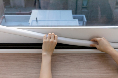 DIY interior hand motion, closeup_put up paper weather stripの写真素材
