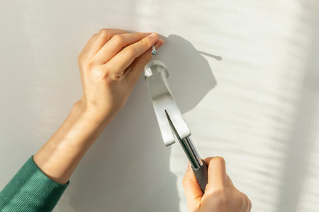 DIY interior hand motion, closeup_hammer a nail into the waの写真素材