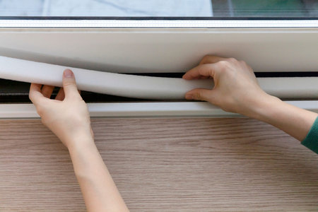 DIY interior hand motion, closeup_put up paper weather stripの写真素材