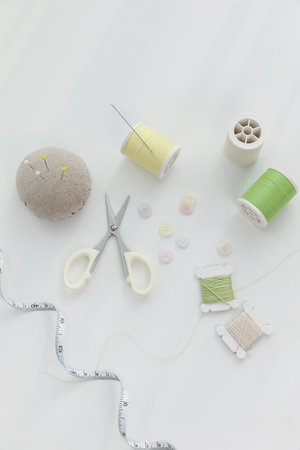 aesthetic photo of handmade, crafting hobbies, thread, button, needle, tape measure.