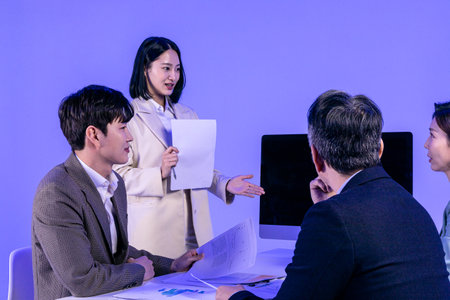 Asian Korean senior, middle aged and young male and female colleagues models in business attire, neon purple studio background, present with confidenceの写真素材