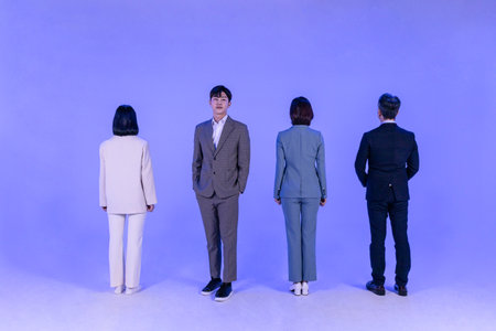 Asian Korean senior, middle aged and young male and female colleagues models in business attire, neon purple studio background, stand in lineの写真素材