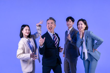 Asian Korean senior, middle aged and young male and female colleagues models in business attire, neon purple studio background, cheerfulの写真素材