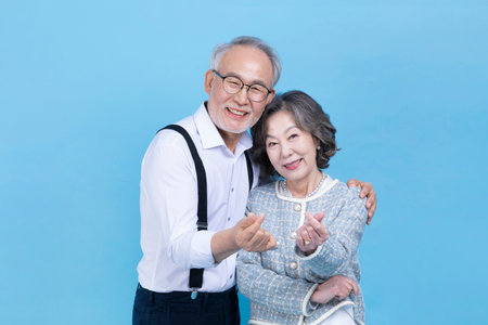 active young senior Korean Asian couple with hand motionの写真素材