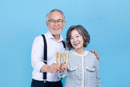 active young senior Korean Asian couple holding champagne glasses