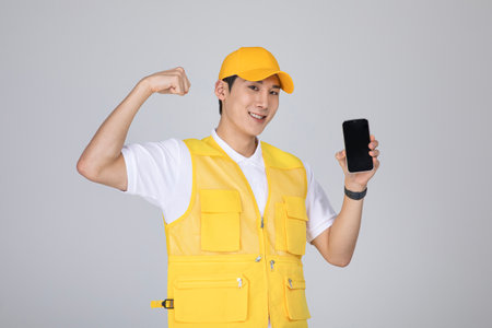 millennials and gen z, korean asian young man holding a smartphone with hand motionの写真素材