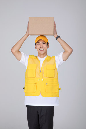 millennials and gen z, korean asian young man holding a parcelの写真素材