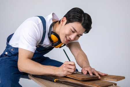millennials and gen z, korean asian young man carpenter sitting and workingの写真素材