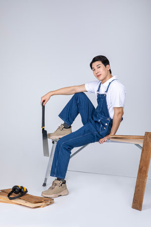 millennials and gen z, korean asian young man carpenter holding tablet pcの写真素材