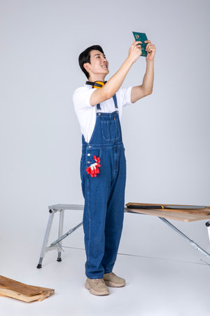 millennials and gen z, korean asian young man carpenter holding a bankbookの写真素材