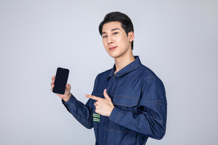 millennials and gen z, korean asian young man, site staff with a smartphoneの写真素材