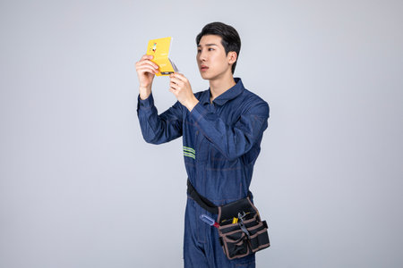 millennials and gen z, korean asian young man, site staff grimacing with a bankbookの写真素材