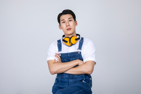 millennials and gen z, korean asian young man carpenter sitting, with crossed armsの写真素材