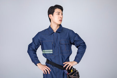 millennials and gen z, korean asian young man, site staff with hands on waistの写真素材