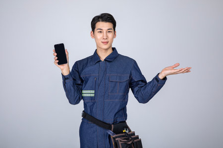 millennials and gen z, korean asian young man, site staff with a smartphoneの写真素材