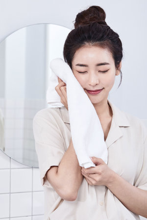 summer lifestyle, korean asian young woman drying face with a towelの写真素材