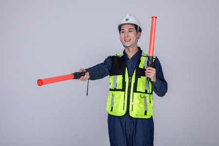 millennials and gen z, korean asian young man, site staff holding a traffic signalの写真素材