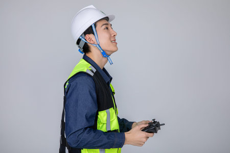 millennials and gen z, korean asian young man, site staff controlling a drone