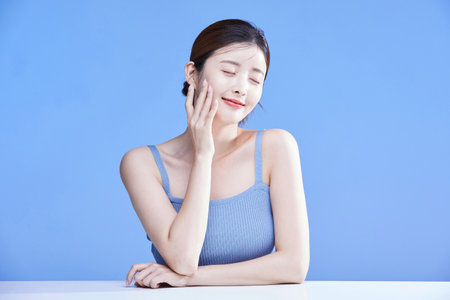 beauty concept photo of korean asain beautiful woman touching her face with her eyes closedの写真素材