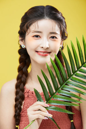 beauty concept photo of korean asain beautiful woman holding a leave and smiling