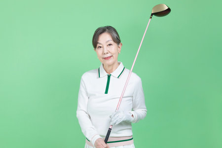 A senior woman holding a golf clubの写真素材