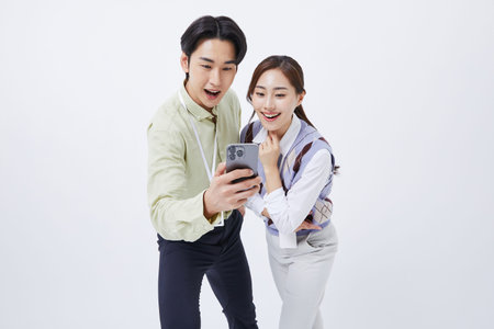 A man and woman smiling at a smartphone