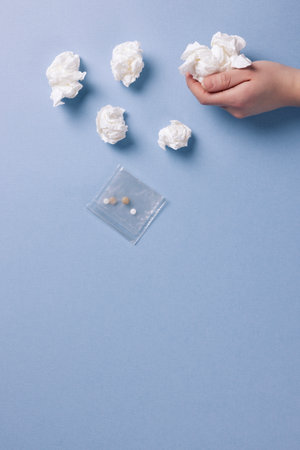 a hand that picks up a bag of medicine and a piece of tissueの写真素材