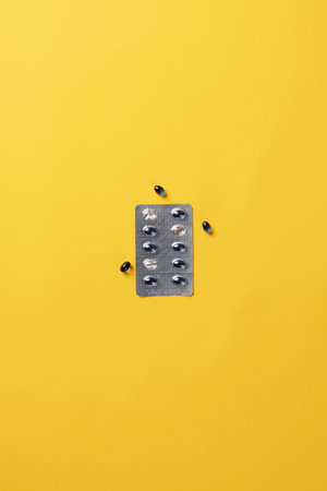 unwrapped capsule packaging on a yellow backgroundの写真素材