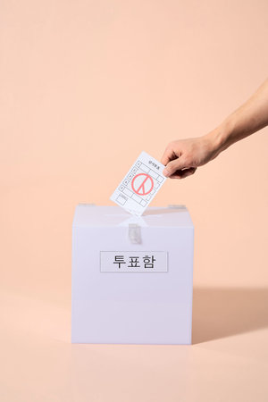 a hand that puts a ballot in the ballot box