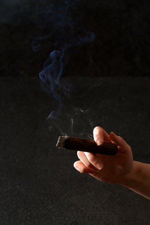 a hand holding a smoking cigarの写真素材