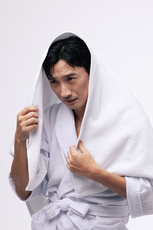 a middle aged man with a white towel around his headの写真素材
