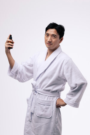 a middle aged man who holds a spray bottle and sprays a mistの写真素材