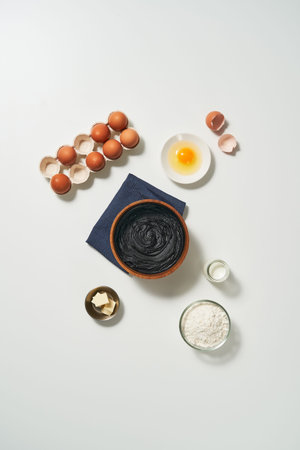 The ingredients for chocolate cake are served in a bowl and a cutting board