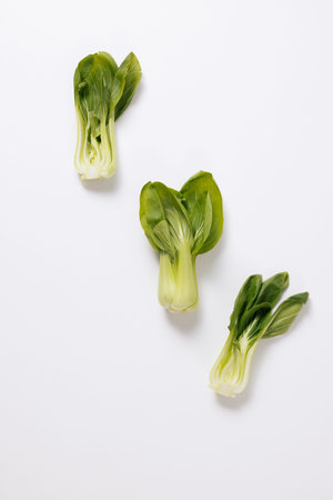 green bok choy arranged on a white background